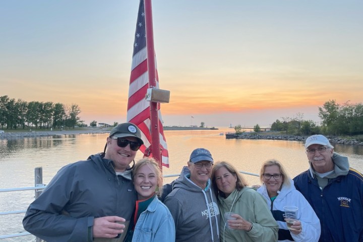 a group of people standing next to a body of water
